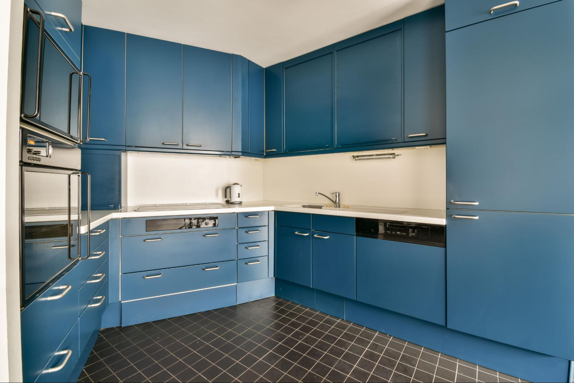 Sleek modern kitchen with blue cabinets and minimalist design.