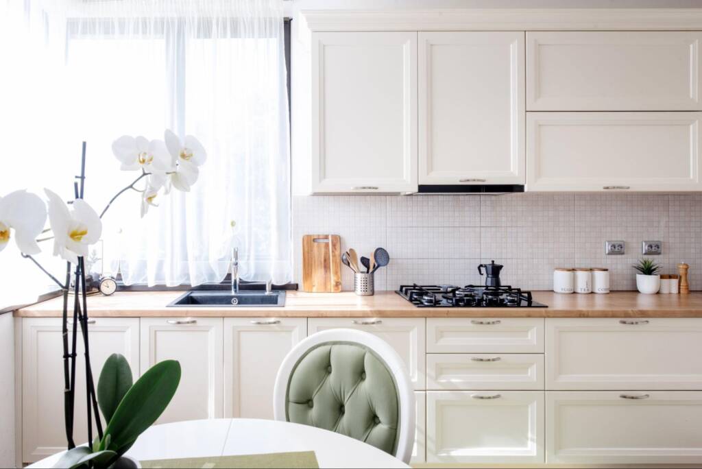 A modern kitchen with wooden countertops and white cabinets.
