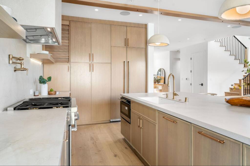 A modern kitchen with white countertops and wooden cabinets.