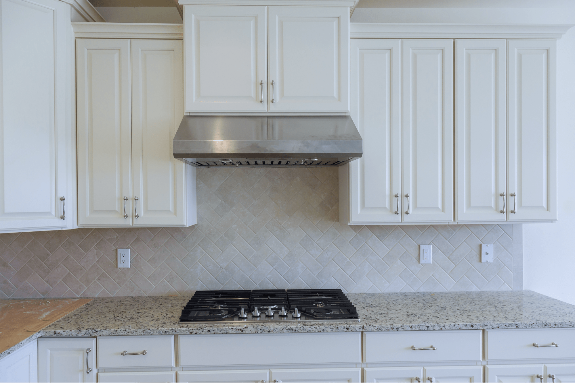 White cabinets with granite countertops beneath them.